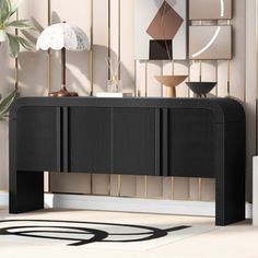 a black console table in front of a wall with art on it