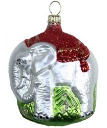 an elephant glass ornament with red and green accents on it's side