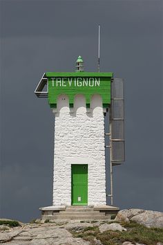 a green and white lighthouse with the word the v - ignn written on it