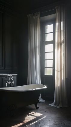 a bath tub sitting next to a window in a room with curtains on the windowsill