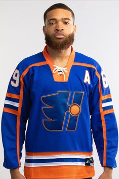 a man wearing an orange and blue hockey jersey