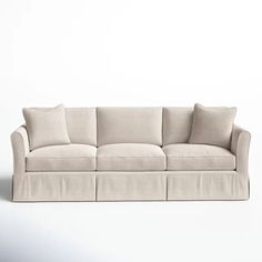 a white couch with four pillows on the back and one arm folded out to form a rectangle shape