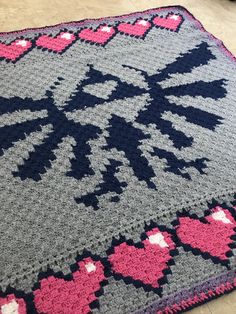 a crocheted rug with hearts on it