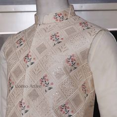 The cream waistcoat is a luxurious piece of clothing made from embroidered fabric with intricate embellishments. Its elegant design makes it perfect for special occasions. The accompanying kurta and pajama are both white and complement the waistcoat beautifully. Here are some key features of the outfit: Luxurious fabric: The waistcoat is made from high-quality embroidered fabric,giving it a rich and luxurious feel.Intricate embellishments: The waistcoat is adorned with delicate embellishments adding to its elegance and sophistication.Elegant design:The overall design of the outfit is classic and timeless, making it suitable for various formal events.Perfect for special occasions: This outfit is ideal for weddings, receptions, and other special celebrations.Comfortable and breathable: The k Designer Raw Silk Nehru Jacket With Floral Embroidery, Eid Floral Embroidered Raw Silk Nehru Jacket, Sleeveless Embroidered Bandhgala For Festive Season, Festive Embroidered Sleeveless Bandhgala, Festive Sleeveless Embroidered Bandhgala, Elegant Kurta With Floral Embroidery, Traditional Sleeveless Bandhgala With Chikankari Embroidery, Designer Sleeveless Bandhgala With Resham Embroidery, Traditional Sleeveless Bandhgala With Resham Embroidery