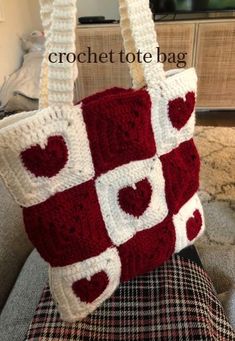 a red and white purse sitting on top of a couch