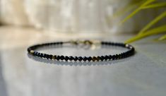 "Tiny black spinel beaded gemstone bracelet with hematite gold beads and gold vermeil claps, bracelet femme is a perfect bridesmaid gift or anniversary present. . ❗️Sign up to our Newsletter and get 15% OFF your order (copy this link to browser search) - https://forms.gle/R74xLdL1MSmC9Apn6 ❗️ . Price is for ONE bracelet ONLY. . MEASUREMENTS: Beads: Black Spinel 2 mm; gold-plated hematite - 2 mm Clasp: Gold vermeil (gold plated 925 sterling silver) Length: You can choose the length of the bracele Unique Beaded Bracelet, Garnet Bracelet, Etsy Bridesmaid Gifts, Quartz Bracelet, Jewelry Bracelet, Gemstone Bracelets, Dainty Jewelry, Gemstone Bracelet, Bridesmaid Gift