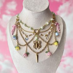 This enchanting gold beaded necklace features multiple layers of delicate chains and beaded strands. Adorned with pastel pink, blue, and yellow Lily of the Valley bead pendants and pink bows. A striking gold spider pendant at the center adds a unique focal point, perfect for those who love a blend of delicate beauty and bold statements. Necklace full length: 37 cm (14.56 inches)   **IMPORTANT NOTICE If you need a longer length, please send me your measurements to ensure your necklace fits proper Whimsical Party Choker Jewelry, Feminine Gold Beaded Necklaces, Whimsical Gold Necklaces With Lobster Clasp, Whimsical Adjustable Gold Necklace, Pink Beaded Necklace With Chain As Gift, Pink Beaded Necklace Chain As Gift, Pink Bohemian Chain Jewelry, Feminine Multicolor Jewelry For Gifts, Cute Pastel Beaded Jewelry