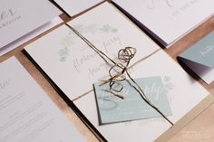 the wedding stationery is laid out on top of each other and tied with twine