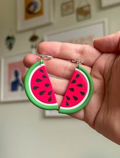 a hand holding a piece of watermelon shaped keychain