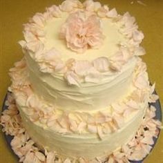 a three tiered cake with white frosting and pink flowers