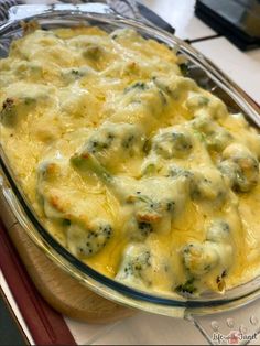 a casserole dish with cheese and broccoli in it on a table