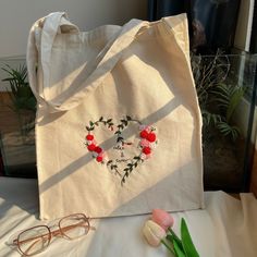 a white bag sitting on top of a table next to a pair of eyeglasses