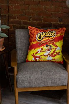 a chair with a pillow on it in front of a brick wall