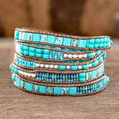 The contrast between blue and turquoise with silvery colored beads inspires soothing elegance. Women artisans from Guatemala's Weaving Hands of Atitlan craft the wrap bracelet by hand with dark brown cords. Artisan Blue Beaded Bracelets, Adjustable Blue Artisan Beaded Bracelets, Adjustable Artisan Blue Beaded Bracelets, Blue Artisan Adjustable Beaded Bracelet, Artisan Turquoise Hand Wrapped Wrap Bracelet, Artisan Hand Wrapped Turquoise Wrap Bracelet, Handmade Artisan Blue Wrap Bracelet, Handmade Blue Wrap Bracelet, Turquoise Beaded Bohemian Wrap Bracelet