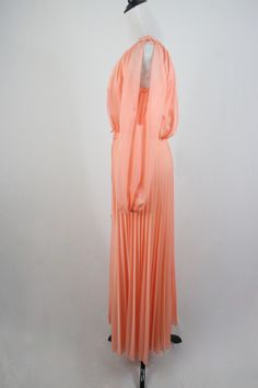 "1970s maxi dress. Peach colored light weight sheer polyester fabric on the outside and lined with an opaque nylon fabric. Long sleeves are unlined and are open from the shoulder to about the elbow with elastic at the wrists. Blousy top, elastic waist, and accordion pleated skirt. There is not a lot of stretch to the waist. Skinny fabric cord belt. Fastens down the back with a metal zipper. Only labels are a size 11/12, ILGWU, and dry clean only. Freshly laundered. (I have to laugh when polyeste Summer Evening Maxi Dress In Peach, Summer Evening Peach Maxi Dress, 1970s Style Maxi Length Lined Dress, Vintage Chiffon Maxi Dress For Spring, 1970s Style Lined Maxi Dress, Vintage Chiffon Maxi Dress For Party, Retro Floor-length Evening Maxi Dress, Flowy Peach Maxi Dress For Party, Peach Flowy Maxi Dress For Party