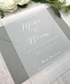 the wedding stationery is set on top of a table with flowers and greenery