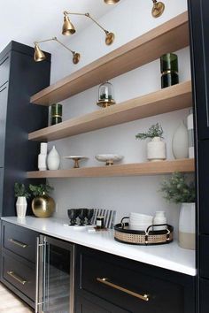 a kitchen with black cabinets and gold accents