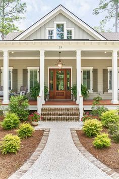 a white house with columns and steps leading to the front door