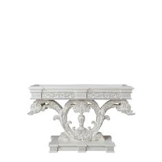 an ornate white console table with carvings on the top and bottom, against a white background