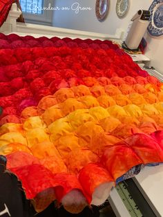 a rainbow colored quilt on top of a stove