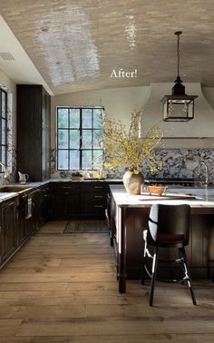 a large kitchen with wooden floors and dark wood cabinets, along with an island in the middle