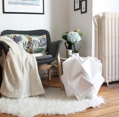 a living room filled with furniture and flowers on top of a white fluffy rug in front of a radiator