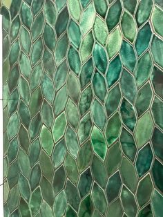 A bunch of leaf-shaped tiles in all sorts of different shades of green running vertically. Leaf Tile Shower Wall, Leaf Tiles Bathroom, Green Outdoor Tiles, Green Leaf Bathroom Ideas, Green Leaf Tile, Green Tile Pattern, Bathroom Forest Theme, Emerald Tile Bathroom, Forest Themed Kitchen