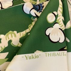 the fabric is green and white with flowers on it's side, as well as words that read yuki thibaut