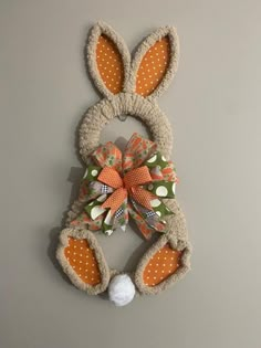 an orange and white bunny ears with polka dots on it's head is hanging from the wall