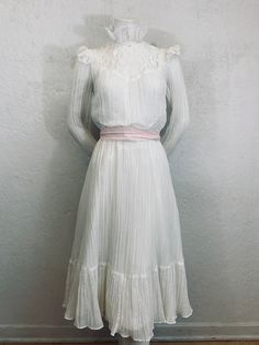 "What a romantic Gunne Sax / Boho style dress! - 1970's - \"Act 1\" label - Gunne Sax / Boho style - Midi length - White crinkled cotton gauze - White light weight cotton lining - Victorian style lace collar - White lace trim on neckline, shoulders, bust, and sleeve cuffs - Bishop sleeves with lace cuffs - 5 pearl buttons on each sleeve - 1 pearl button closure on back of neck - Two belt loops on side - Pink sash belt - Elastic waist - Ruffle panel on bottom of skirt - Polyester zipper Measureme Vintage Victorian Dress For Spring Formal, Spring Vintage Victorian Dress For Formal Occasions, Spring Formal Vintage Victorian Dress, Spring Victorian Vintage Dress, Feminine White Vintage Dress For Formal Occasions, Spring Victorian Dress In Vintage White, Fitted Vintage Prairie Dress For Vintage Events, White Vintage Victorian Dress For Spring, Vintage Prairie Dress For Spring Formal Occasions