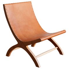 a brown leather chair sitting on top of a wooden frame with studded straps and legs