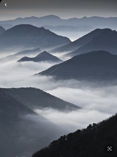 the mountains are covered in fog and low lying clouds