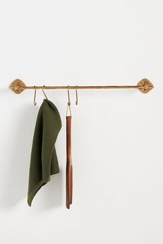 a pair of green towels hanging on a clothes line with an iron bar and wooden handle