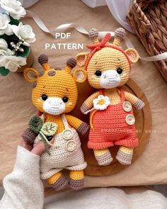 two crocheted stuffed animals sitting on top of a wooden plate