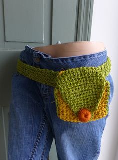 a woman's jeans with a crocheted purse on the bottom and an orange ball in the pocket