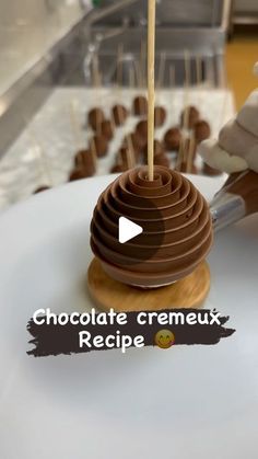 the chocolate cremeux recipe is being made by a person in white gloves holding a wooden skewer