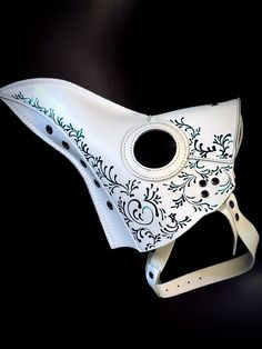 Our white plague doctor mask is intricately designed to evoke the enigmatic spirit of the past. This mask is perfect for long periods of wear as it is crafted with vegan leather, making it comfortable and breathable. White/Green Color.

Age Group/Gender - Adult/Unisex
Size/Type - One size fits all adults
Mask Color - White
Filigree Color - Green
Mask Material - Vegan Leather White Plague Doctor, Beak Mask, Plague Doctor Costume, Plague Doctors, Green Mask, Plague Mask, Plague Doctor Mask, Doctor Mask, Diy Leather Projects