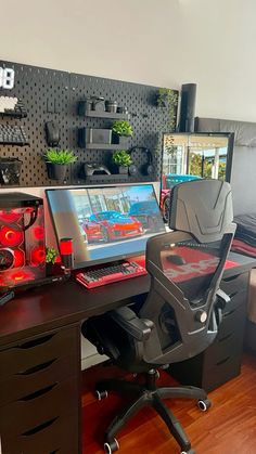 a desk with a computer on top of it next to a chair and other items