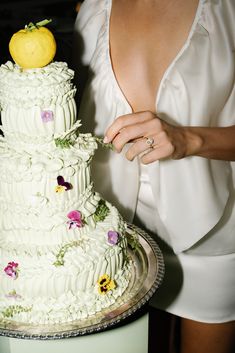 a bride and groom cutting their wedding cake with an apple on top at the reception