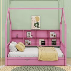 a pink bed frame with bookshelves and pillows on it in a green room