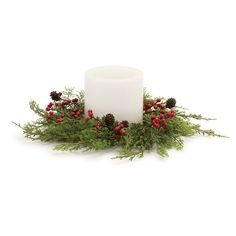 a white candle surrounded by greenery and pine cones on a white background with red berries