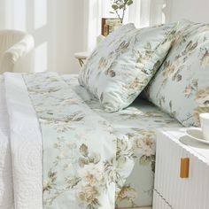 a bed with white sheets and flowers on it