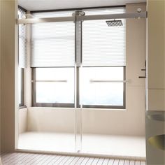 an empty bathroom with sliding glass doors and tile flooring, along with white walls