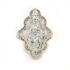 Antique Eduardian circa 1910 Diamond Ring in 14 karat white gold on Etsy, $2,575.00 Antique Platinum Three-stone Jewelry, Three Stone Diamond Ring In 14k Silver Gold, 14k Gold Three Stone Diamond Ring, 14k Gold Diamond Ring With Three Stones, Heirloom Silver Filigree Ring With Intricate Design, Ornate Diamond-cut Filigree Ring, Victorian Silver Filigree Ring With Diamond Accents, Victorian Platinum Filigree Jewelry, Vintage Silver Filigree Ring With Diamond Accents