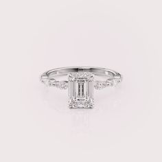 Make a grand statement of love with this magnificent 2.5 carat emerald cut lab diamond engagement ring. The captivating center stone boasts a timeless rectangular shape, radiating brilliance with its clean lines. A hidden halo of sparkling round diamonds adds a touch of magic, enhancing the center stone’s fire from every angle. Delicate marquise diamonds adorn the sides of the band, creating a vintage-inspired elegance and a touch of modern flair. Crafted in warm 14k yellow gold, this ring is a timeless symbol of love and commitment, perfect for the woman who appreciates classic beauty with a touch of modern detail. ✤𝐂𝐞𝐧𝐭𝐞𝐫 𝐃𝐢𝐚𝐦𝐨𝐧𝐝 𝐃𝐞𝐭𝐚𝐢𝐥𝐬 Color: F Clarity: VS1 Shape: Emerald Cut Carat Weight: 2.5CT Approx. Type: Lab Grown Diamond(CVD/HPHT) ✤ Ring 𝐒𝐢𝐝𝐞 𝐃𝐢𝐚𝐦𝐨𝐧? Timeless Emerald Ring With Radiant Diamond Cut, Square Cut Emerald Ring With Diamond For Promise, White Emerald Ring With Diamond Accents, Emerald Cut Diamond White Rings For Proposals, Emerald Cut Diamond White Emerald Ring With Diamond Accents, Luxury Rectangular Diamond Anniversary Ring, Diamond White Emerald Cut Emerald Ring With Diamond Accents, Timeless Diamond White Emerald Cut Ring, Luxury Diamond Ring With Rectangular Stone For Anniversary