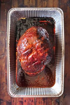 a roasting pan filled with meat on top of a wooden table