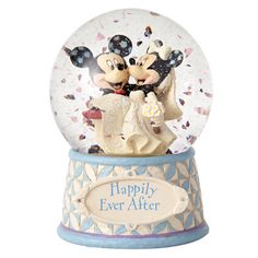 a snow globe with mickey and minnie kissing on it's face, in front of a white background