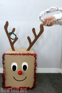 a cardboard box with reindeer's head and antlers on it is being held by someone