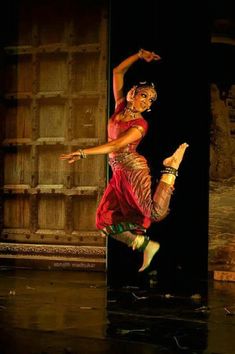 a woman in red and gold dancing on stage