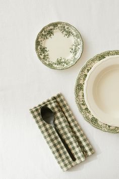 green and white place setting with two plates, one fork and the other empty plate